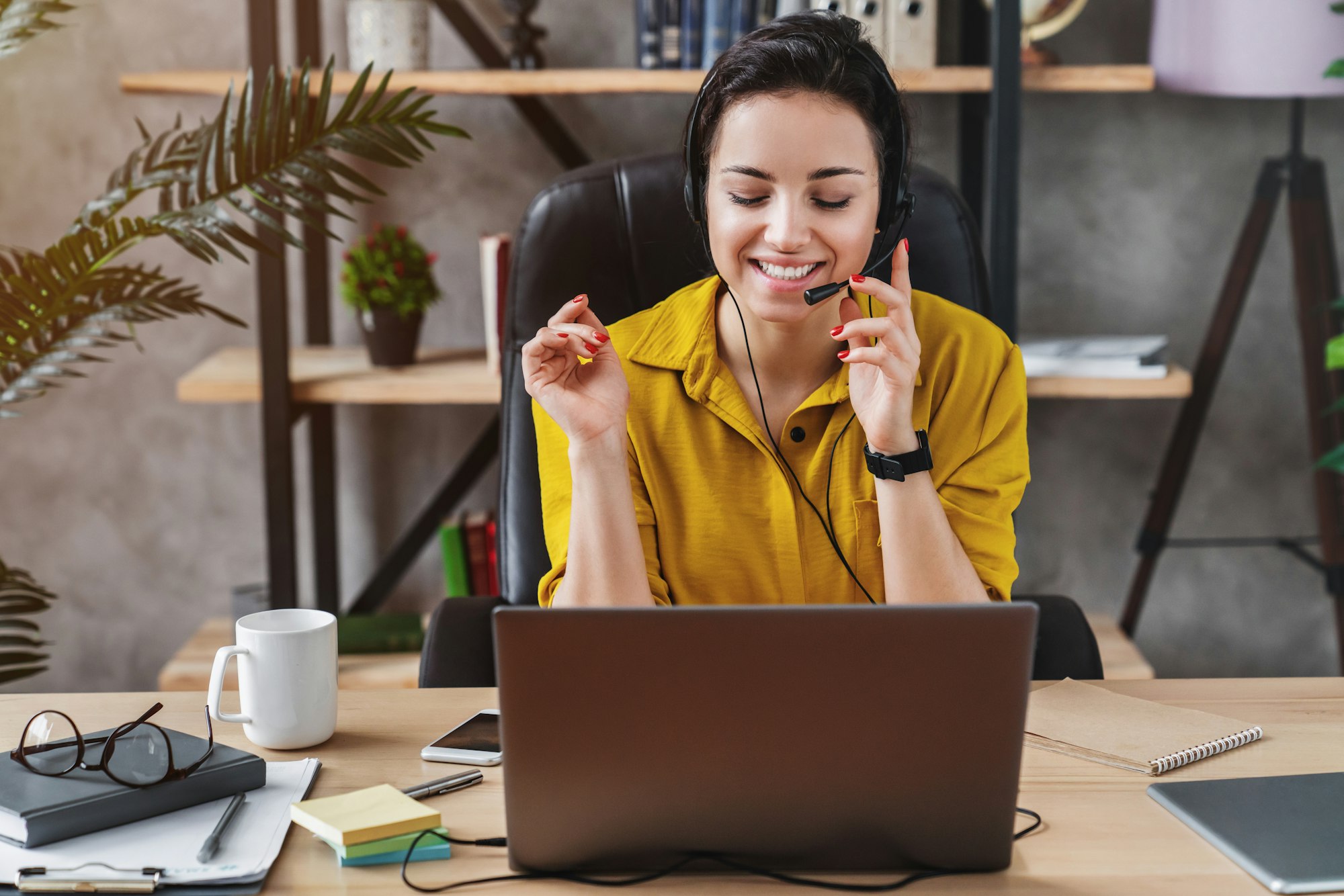 Teleoperator working in office with laptop and headset on